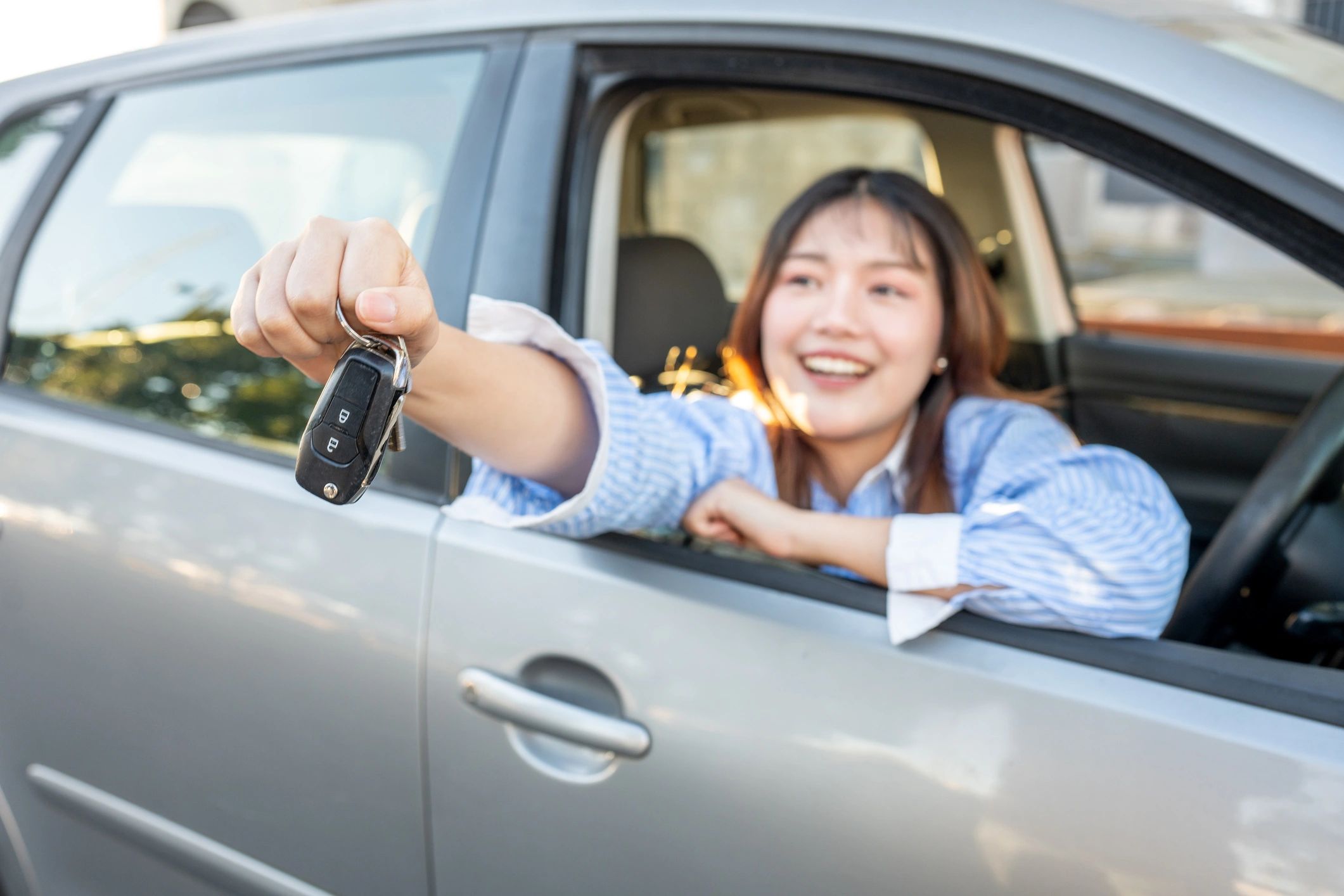 Young driver holding car keys