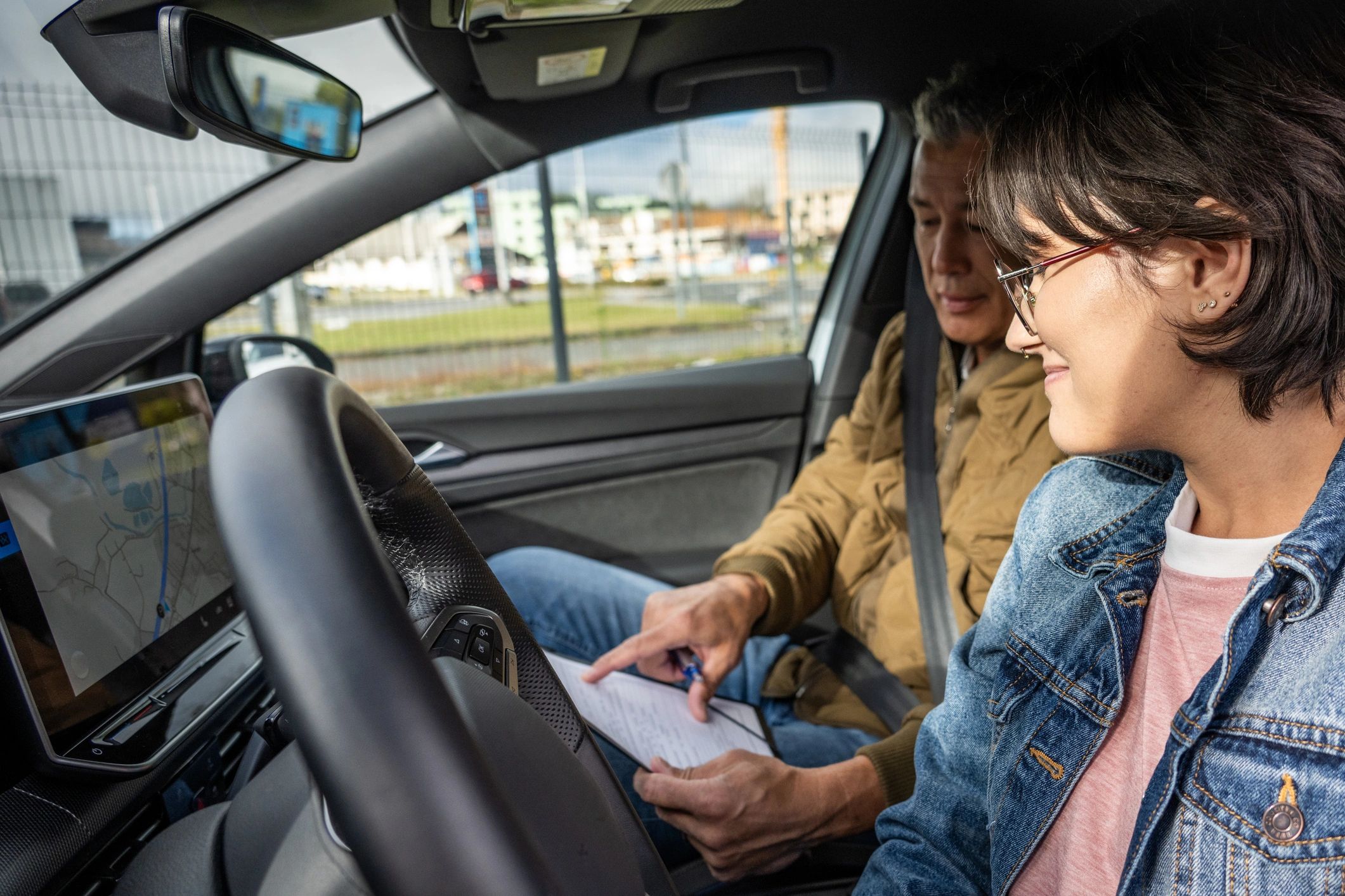 Student driver learning inside a car with an instructor