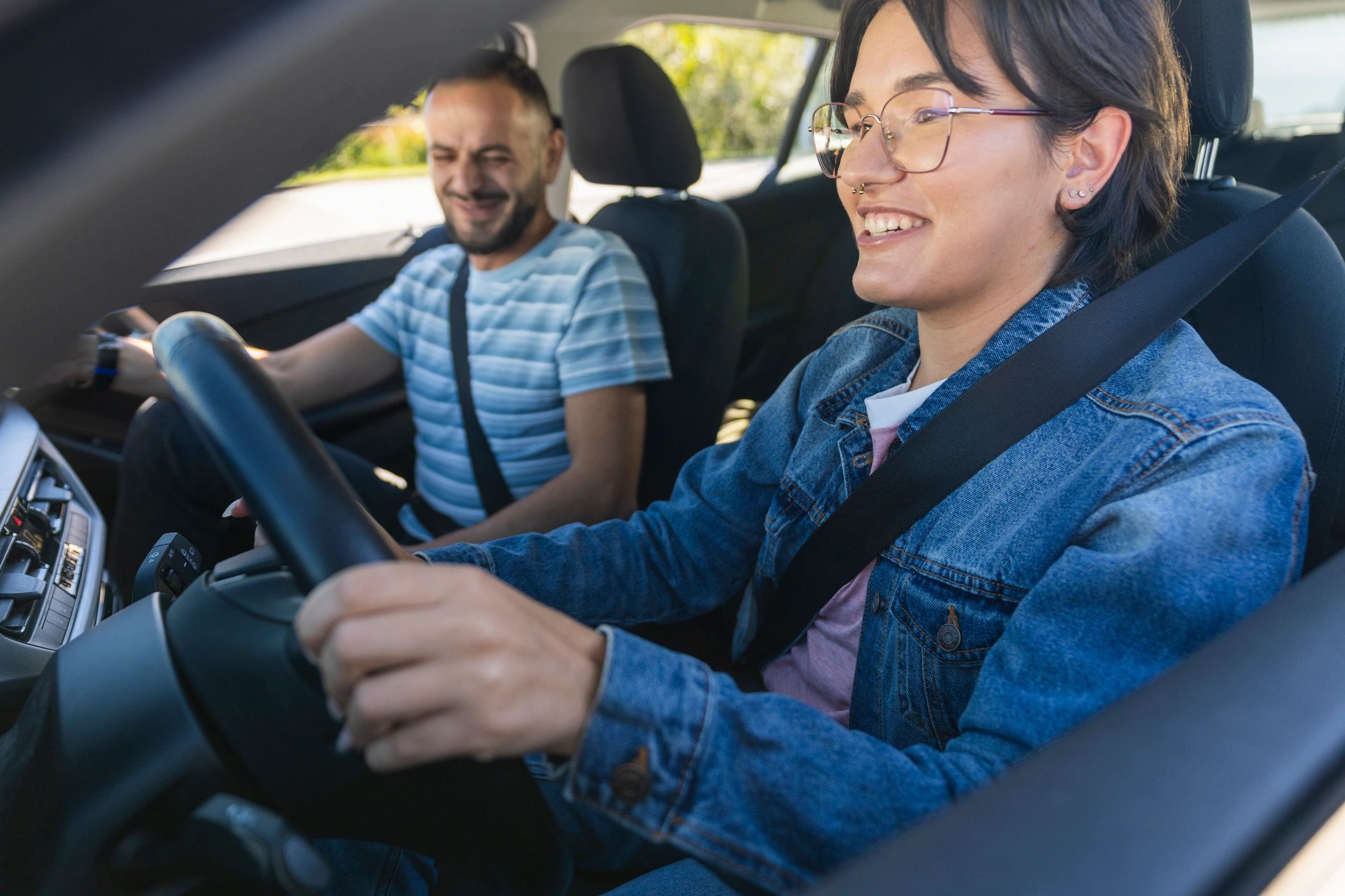 Driving instructor observing a student controlling the steering wheel
